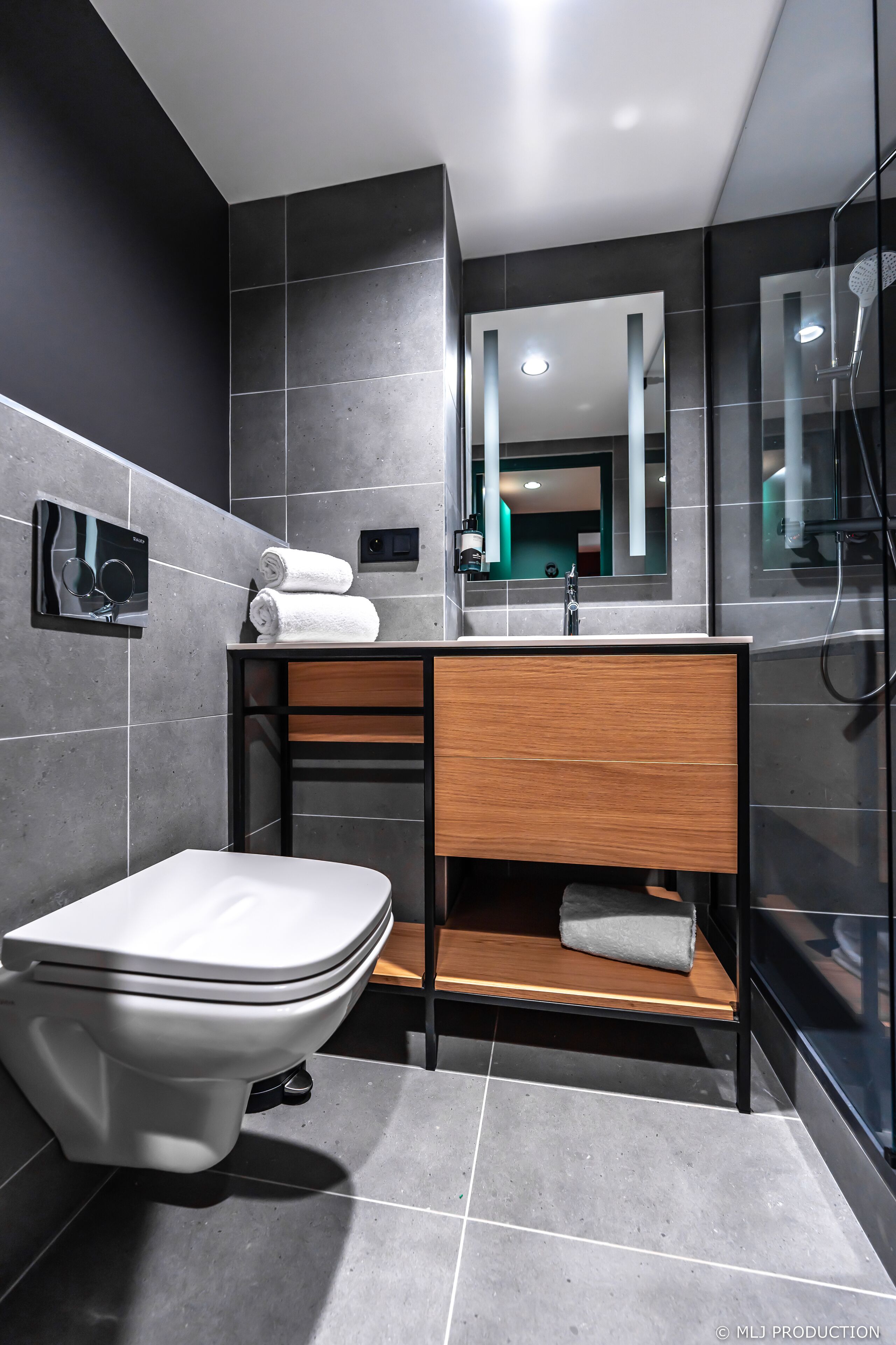 A modern bathroom with a toilet, sink, and shower.