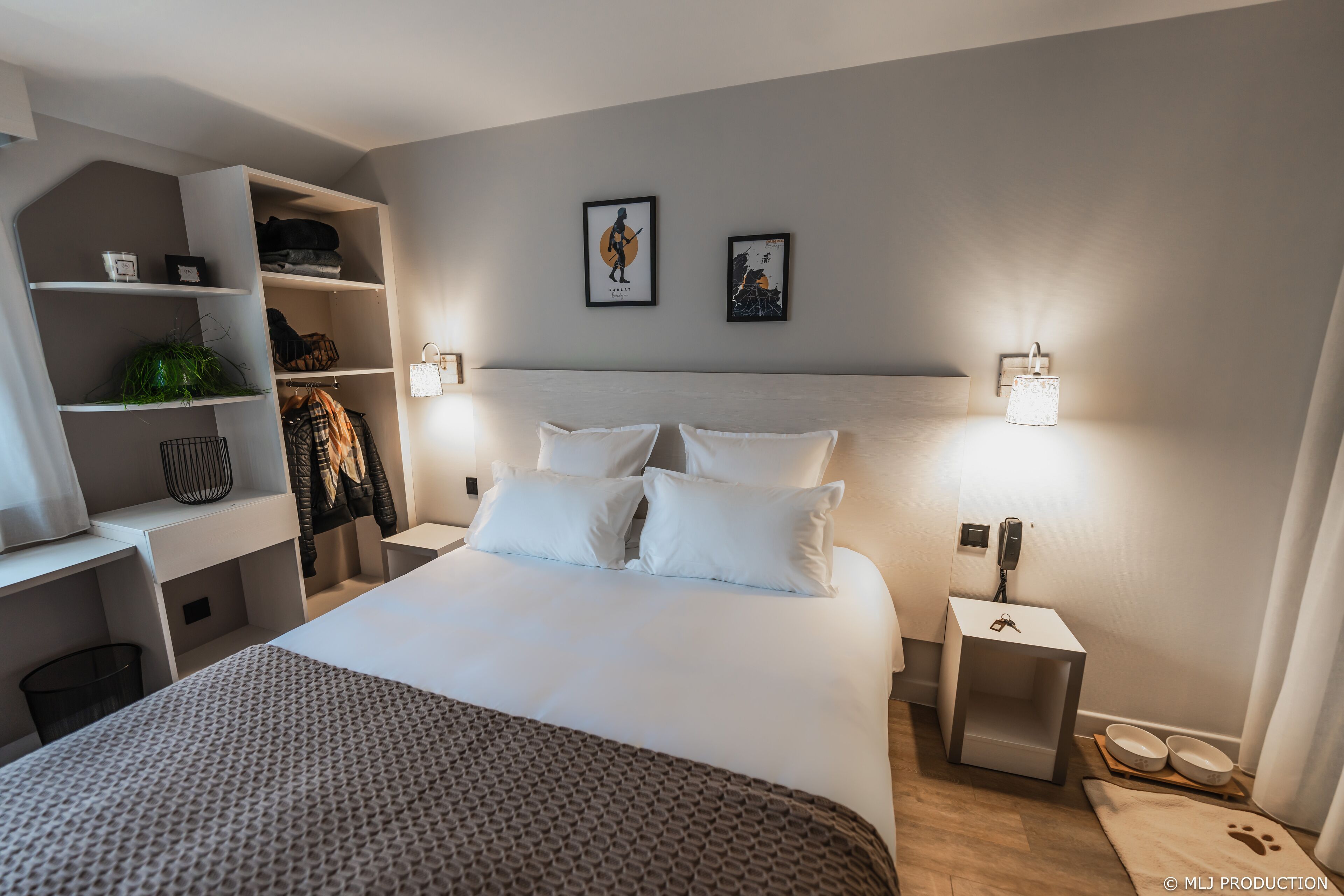 A neatly organized bedroom with a large bed, a built-in wardrobe, and a bedside table with a lamp.