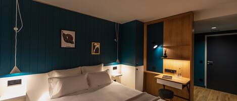 A modern bedroom with a bed, bedside tables, a desk, and a wardrobe.
