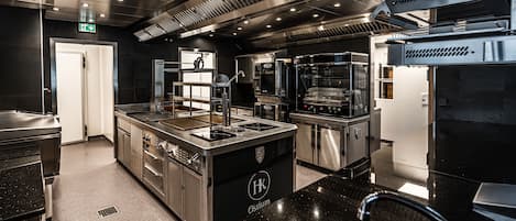 Una cocina moderna con electrodomésticos de acero inoxidable, una isla central con pileta y un logotipo en la isla.