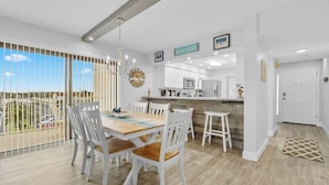 A modern kitchen with a central island, white cabinetry, and a view of the outdoors.
