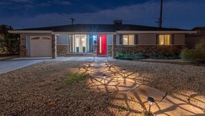 A modern two-story house with a red door, a garage, and a driveway with decorative lights. - Pool & Art Lover Oasis near Old Town w/ Mini Golf (Scottsdale)