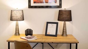 A wooden desk with two lamps, a framed certificate, and a small black basket. - Art-Lover’s Suite - Minutes to Crystal Bridges (Bentonville)
