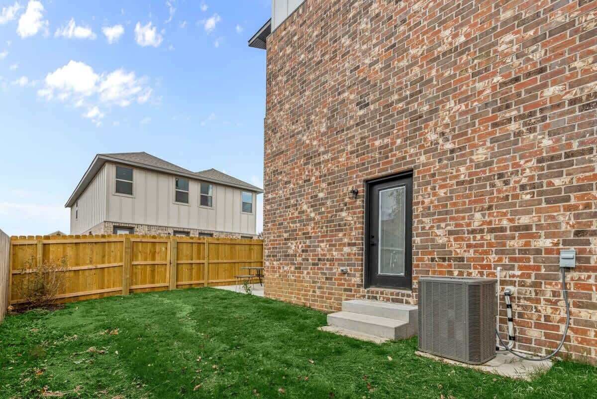 A brick building with a black door and an air conditioning unit.
