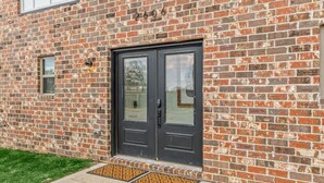 A brick building with a double door, a small window, and a mailbox. - Bentonville Art Suite • Near Crystal Bridges & Osage Park (Bentonville)