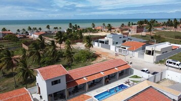 Un área residencial costera con edificios modernos, una piscina y vista al océano.