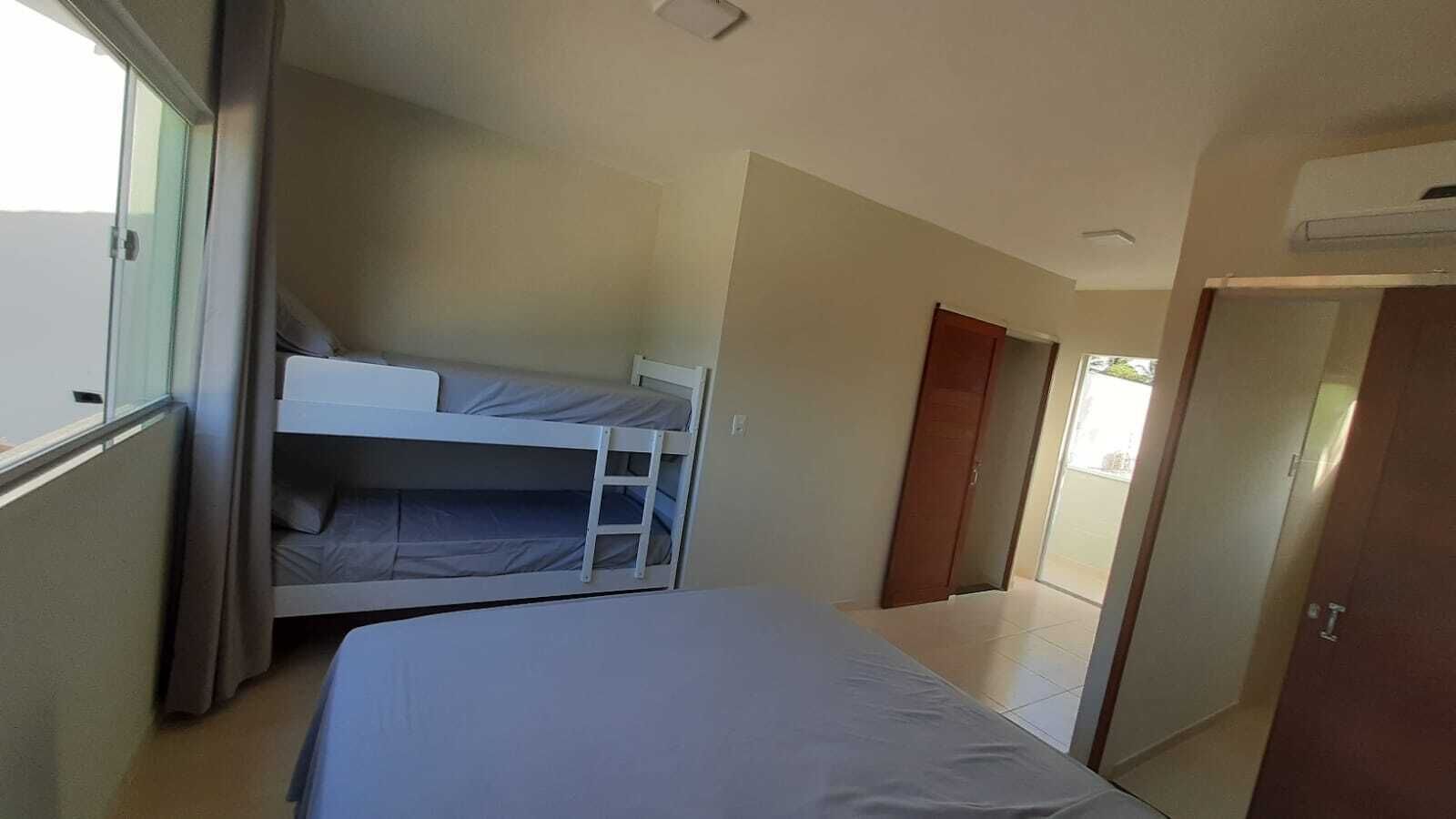 A room with bunk beds, a door, and a window.