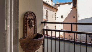 A balcony with a wrought iron railing, a wooden door with a lion head knocker, and a terracotta pot. - Ricasoli Apartment - Two Bedroom Apartment, Sleeps 4 (Firenze)