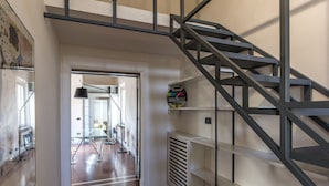 A modern interior with a staircase, a glass table, and chairs in a hallway. - Ricasoli Apartment - Two Bedroom Apartment, Sleeps 4 (Firenze)