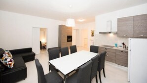 A modern apartment with a dining area, kitchen, and a living room.