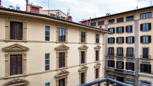 Um edifício com vários andares e características arquitetônicas clássicas, incluindo janelas simétricas e molduras decorativas.