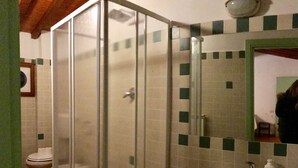 A bathroom with a glass-enclosed shower, a white sink, and a tiled wall with a green and beige pattern. - Alfani second floor - Three Bedroom Apartment, Sleeps 5 (Firenze)