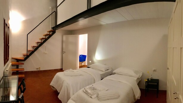 A hotel room with two beds, a glass table, and a staircase. - Alfani second floor - Three Bedroom Apartment, Sleeps 5 (Firenze)