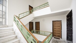 A multi-level interior with marble stairs, green railings, and wooden doors. - Buonarroti Apartment (Firenze)