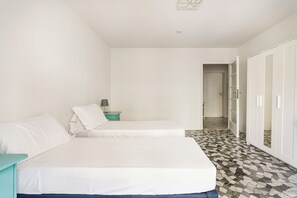 Ein Schlafzimmer mit zwei Betten, einem Nachttisch, einer Lampe und einem Kleiderschrank.