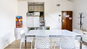 A modern kitchen with white cabinets, a microwave, and a wooden door. - Faenza 73 - Three Bedroom Apartment, Sleeps 5 (Firenze)