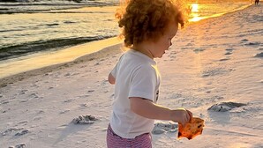A child playing on a sandy beach with footprints and a sunset in the background. - Destin Festival!!  Sept 24 - 28 Available (Fort Walton Beach)