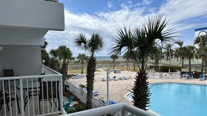 A pool area with lounge chairs and palm trees, overlooking a beach and ocean. - Destin Festival!!  Sept 24 - 28 Available (Fort Walton Beach)