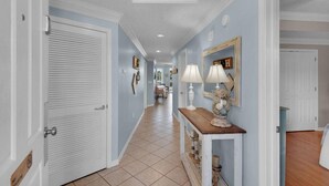 A hallway with a tiled floor, white doors, and a console table with a lamp. - Destin Festival!!  Sept 24 - 28 Available (Fort Walton Beach)