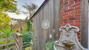 Ein Holzhaus mit Backsteinmauer, schmiedeeisernem Detail und Holzzaun.
