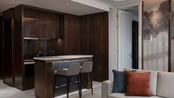 Una cocina moderna con armarios de madera oscura, una isla central con taburetes de bar y encimera de color claro.