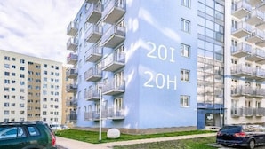 A modern apartment building with balconies and a large number '201' on the facade.