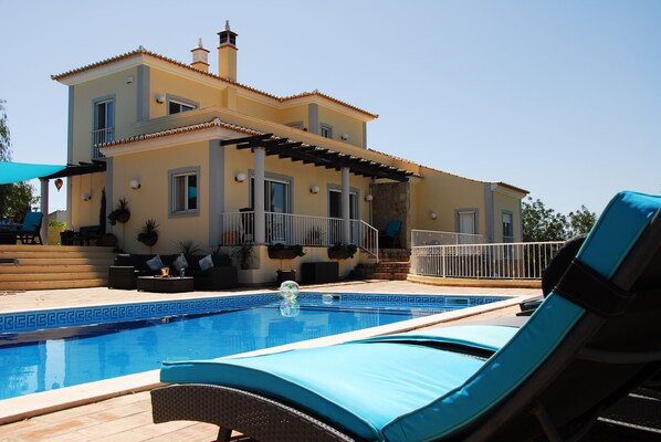 A two-story house with a swimming pool, outdoor furniture, and a pergola. - Escape & Unwind in Elegance with Large Private Pool & Amazing Views (Free Wi-Fi) (Sao Bras de Alportel, Algarve)