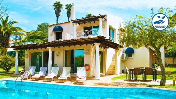 A two-story house with a pool, white columns, and a balcony. - Cozy Villa w/ Heatable Pool & BBQ (Albufeira)