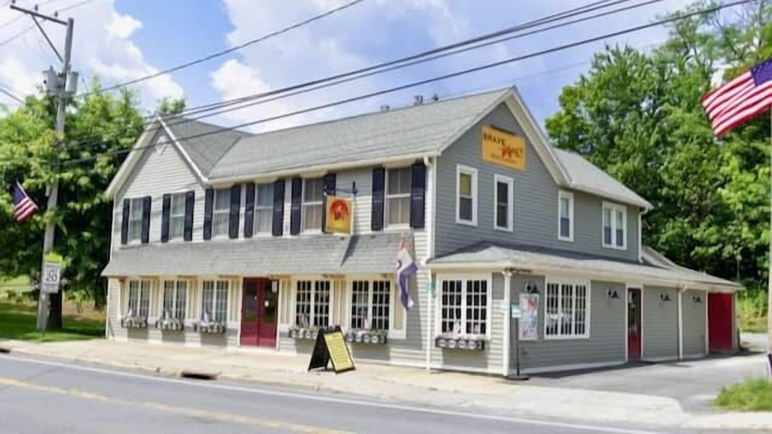 A two-story building with a red door and multiple windows.