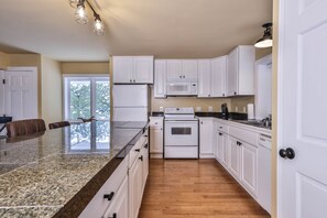 Horno, parrilla de estufa, comedor y isla de cocina 