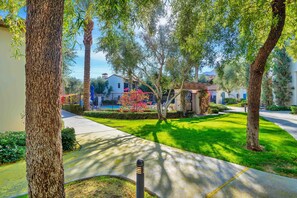 A residential area with a well-maintained lawn, mature trees, and a clear pathway. - Fabulous King 2BR/2BA/2Car Legacy Villa near Pool (La Quinta)