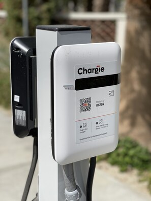 A public charging station with a white box labeled "Charge" and a QR code for station ID 06759. - Fabulous King 2BR/2BA/2Car Legacy Villa near Pool (La Quinta)