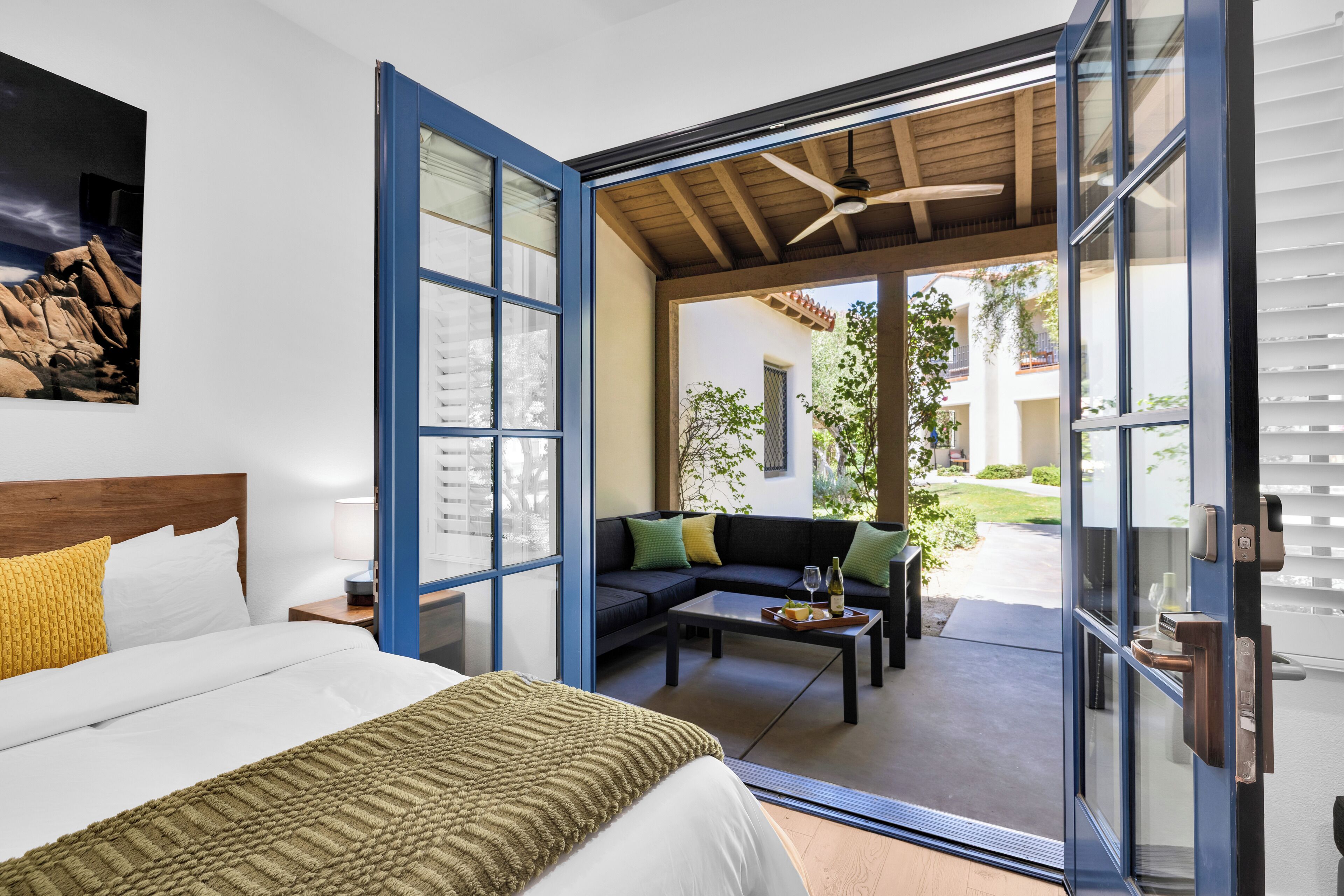 A bedroom with a bed, a sofa, and a dining table.