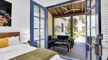 A bedroom with a bed, a sofa, and a dining table.