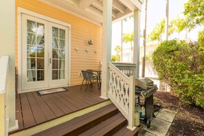 A wooden deck with a white railing, a grill, and a table with chairs. - Beautiful Island Home in Anglers Reef! Ocean front community. Pool & boat slip.  (Islamorada)