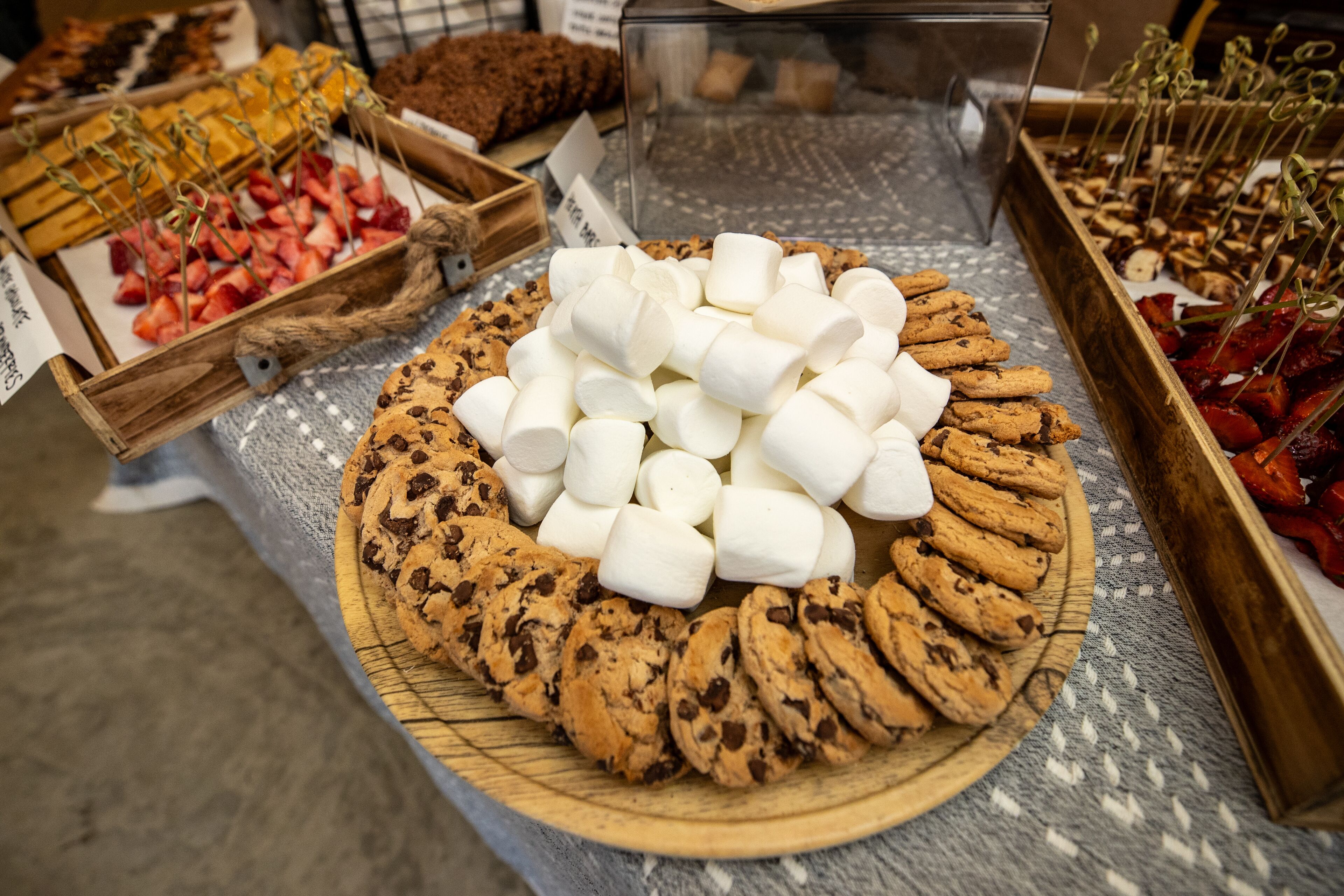 A display of cookies and marshmallows on a wooden board.