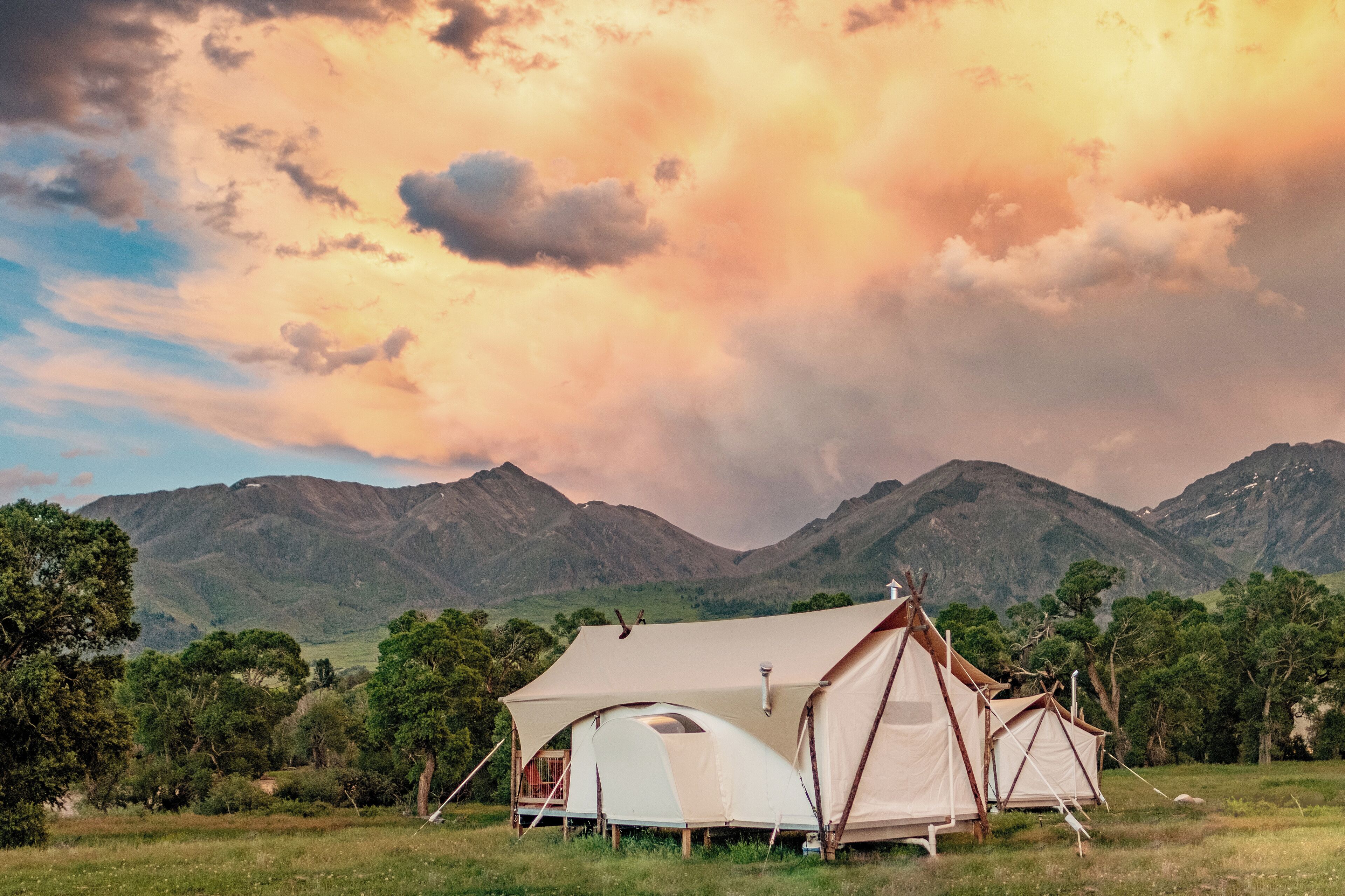 A tented campsite with a mountain backdrop.