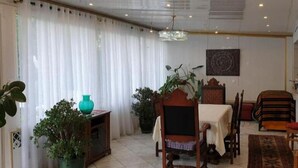A dining area with a table, chairs, a chandelier, and potted plants. - baroque villa (Pierrefitte-sur-Seine)