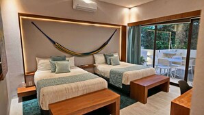 Ein modernes Hotelzimmer mit zwei Betten, einer Hängematte und einem Balkon mit Sitzgelegenheit.