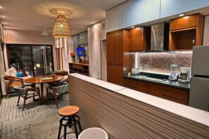 Una cucina moderna con zona pranzo, mobili in legno e una grande isola.