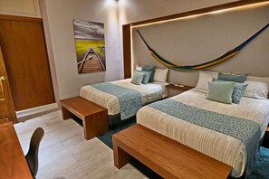 Une chambre dâhĂŽtel avec deux lits, un banc, un bureau et un hamac.