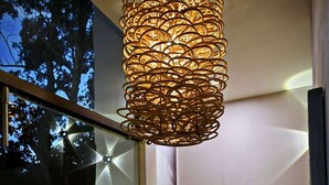 Ein modernes Interieur mit einer außergewöhnlichen Pendelleuchte, einer Glastür zum Außenbereich und einer kleinen Sitzecke mit Tisch und Stühlen.