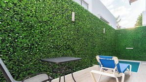 A patio with a table and chairs, a pool, and a green hedge wall. - Wow! Gated House/WiFi/5 rooms/12 pax/Pool Private (Cancún)