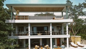 A two-story modern house with a swimming pool, outdoor seating, and lush greenery. - La Musa de la Jungla (Nosara)