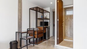 Ein kleines Zimmer mit Schreibtisch, Stuhl und integriertem Bücherregal.