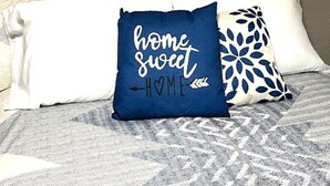 A bedroom with a bed, a decorative wreath, and a pillow with the text "home sweet home." - Salmon Goldbug Cottage, hot tub sleeps 8 (Salmon)