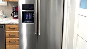 A stainless steel refrigerator with a water dispenser, wooden cabinets, a coffee maker, and a dishwasher in a kitchen. - Salmon Goldbug Cottage, hot tub sleeps 8 (Salmon)