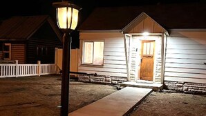 A wooden house with a porch and a light post in front. - Salmon Goldbug Cottage, hot tub sleeps 8 (Salmon)