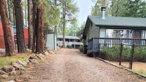 A gravel path leading to a building with a porch, surrounded by trees and a fenced area. - A/C! Cabin in Strawberry Cool for Summer. Warm for Winter, Elk, and Relax. (Pine)