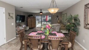 A dining area with a round table, chairs, and a chandelier. - Spacious 2BR/2.5BA Two-Story Beach House, Pet Friendly, FREE Golf Cart Included (Panama City Beach)